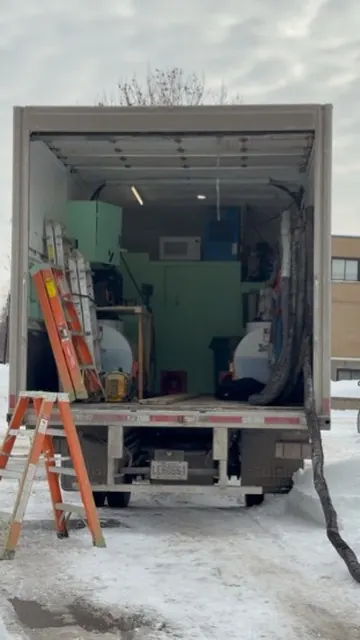 Camión de Kasa cargado de materiales frente a una obra de Montreal