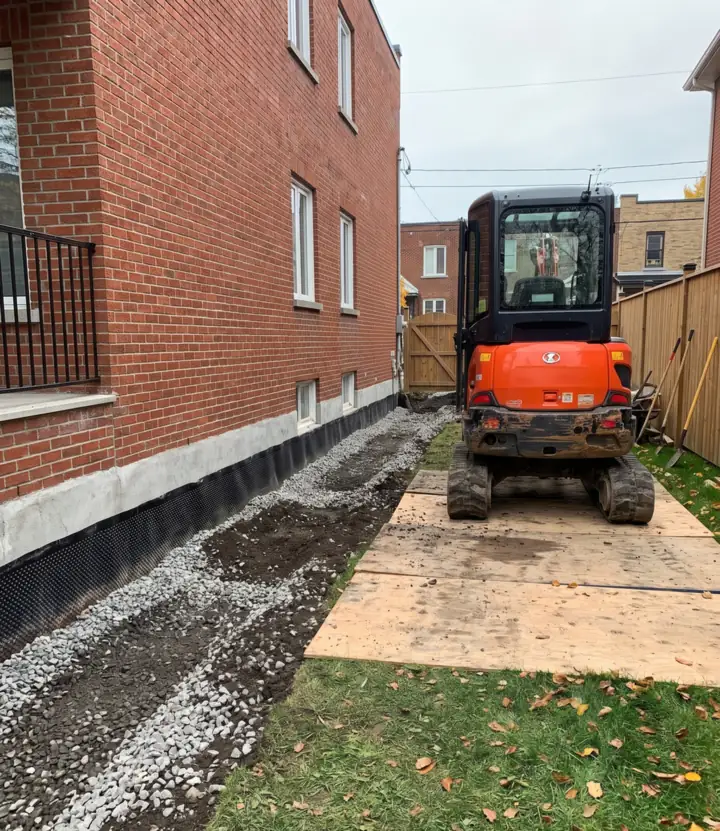 Backfilled trench and yard graded to slope away from a foundation after a French drain installation